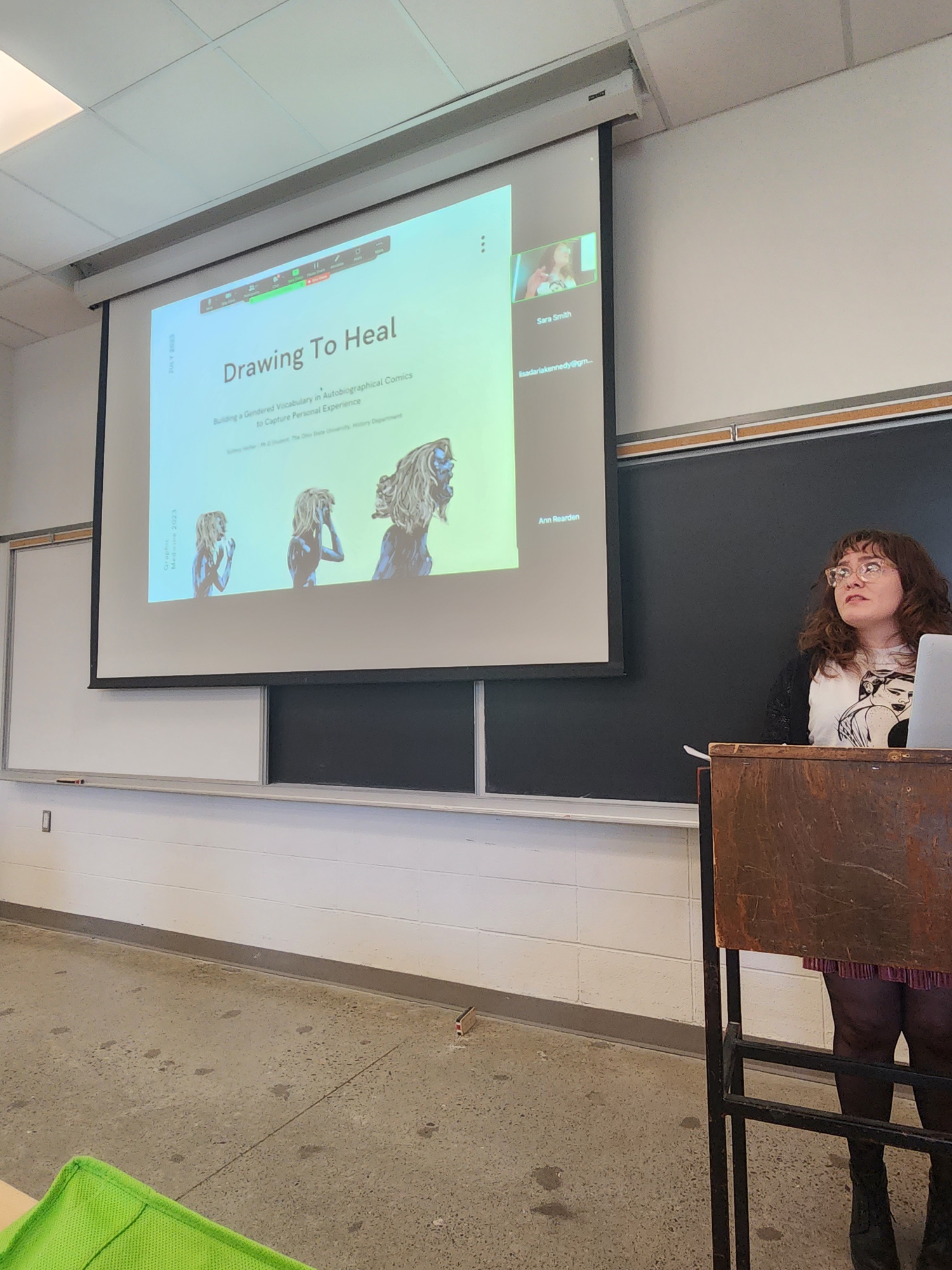 Sydney presenting on her comics How I Leave You and Let Me Out of Here at the Graphic Medicine Conference in Toronto, Canada in 2023.